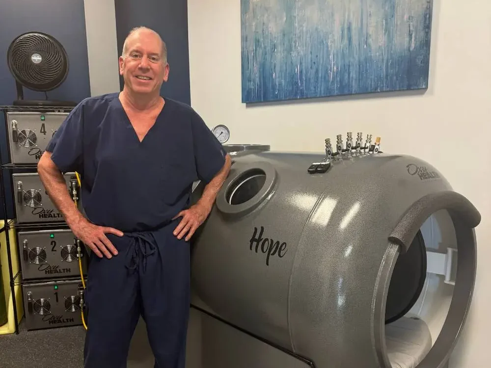 Doctor standing in front of hyperbaric chamber